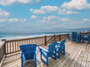 A wooden deck with blue chairs and a table overlooking the ocean. - Bel Sole (Beautiful Sun) by Topsail Realty (Holly Ridge)