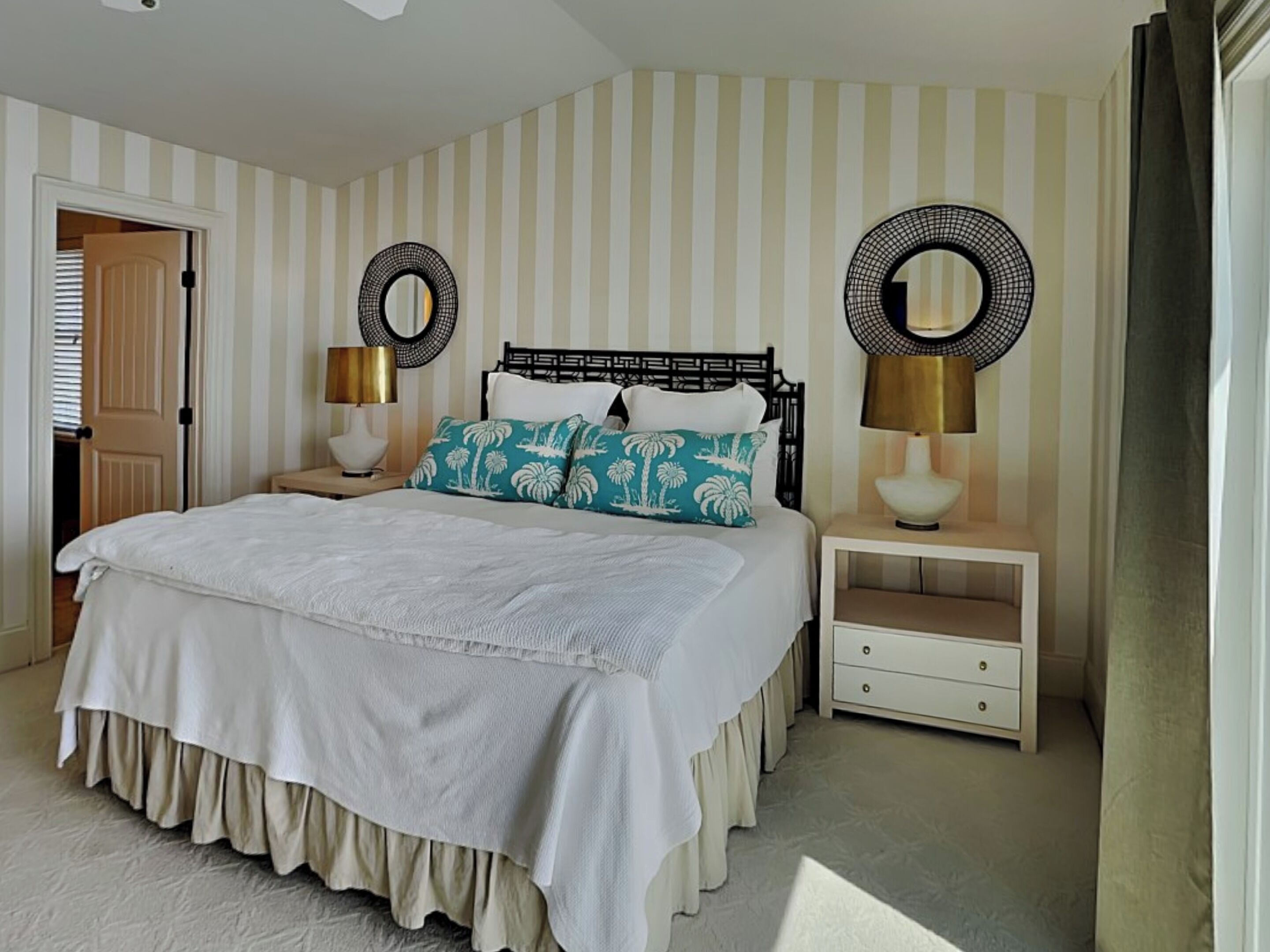 A bedroom with a bed, two bedside tables, and two wall-mounted lamps.