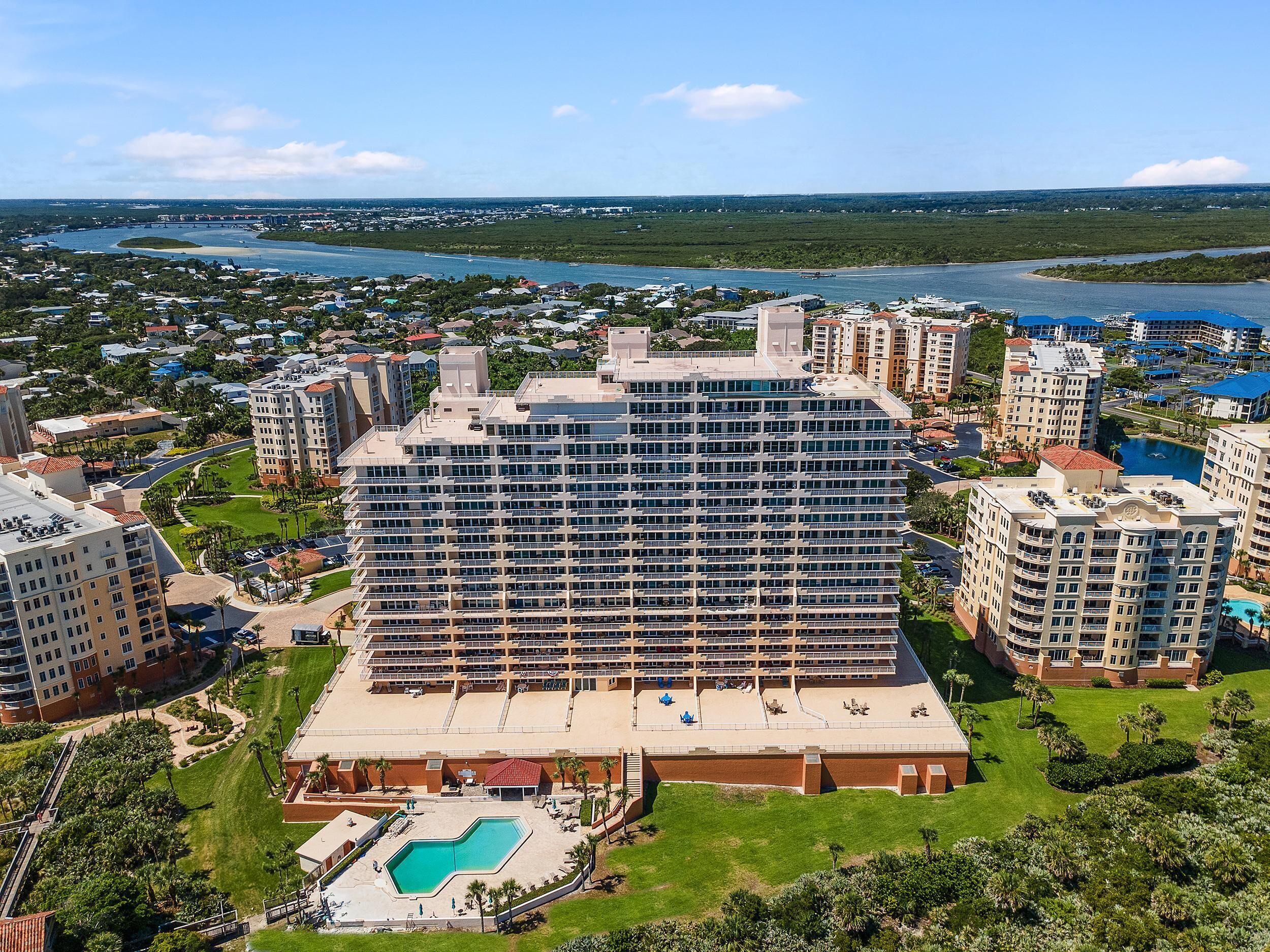 A high-rise hotel with a central courtyard and a swimming pool.