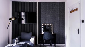 A modern room with a black sofa, a desk with a vanity mirror, and a standing lamp. - Charming Dartford Apartment - Ideal for Explorers! (Dartford)