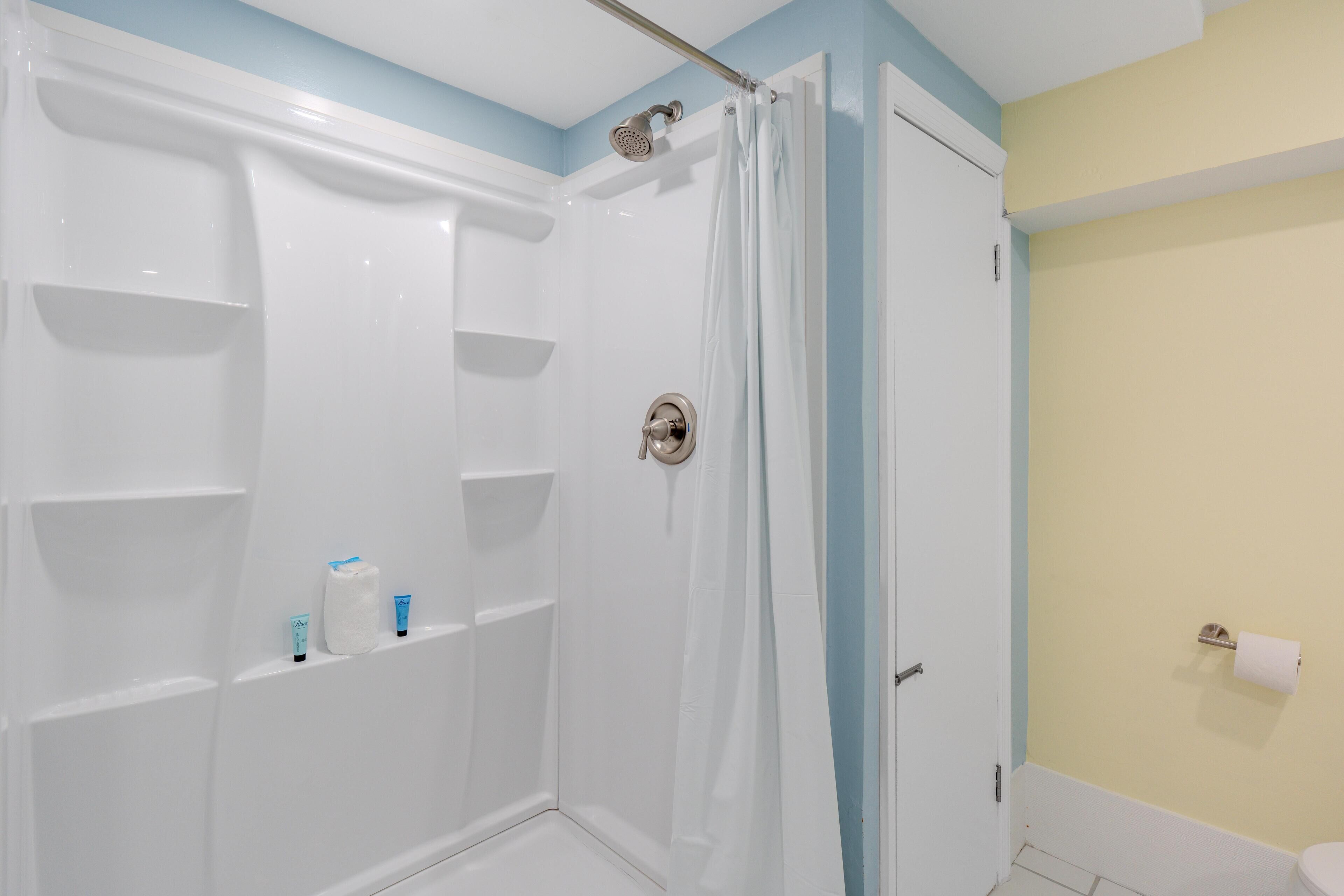 Une salle de bain avec une douche, des toilettes et un lavabo.