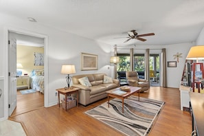 Relax in this open-plan living space with a comfortable sofa, wooden coffee table, and patterned rug.