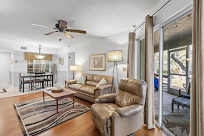 Relax in a spacious living area with a sofa, armchair, and dining table, perfect for meals and comfortable seating.