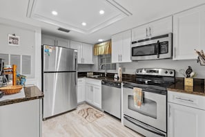 Enjoy cooking in this well-equipped kitchen with a refrigerator, dishwasher, and oven, plus ample storage in the white cabinetry.