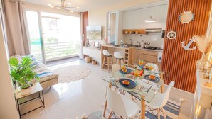 A modern apartment with a dining area, kitchen, and a balcony with a view. - Appart Nautic Piura (Piura)