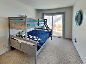 A bunk bed room with a view to an outdoor patio.
