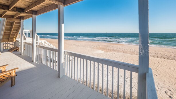 A wooden beach deck with a view of the ocean.
