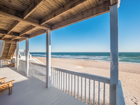 A wooden beach deck with a view of the ocean.