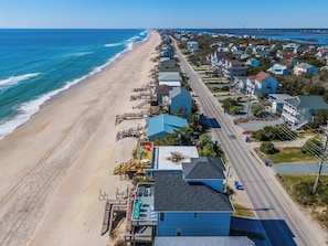 A coastal town with a beach, houses, and a road.