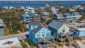 A coastal residential area with houses featuring balconies and wooden decks. - Clamalot by Topsail Realty (Holly Ridge)