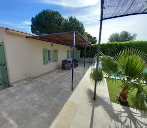 A covered outdoor area with a pool, a palm tree, and a building with green shutters. - Villa Césarine: Sublime 4☆ property, private pool, pool house and outbuilding (Saint-Paul-les-Fonts)