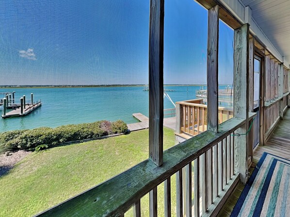 A view from a balcony overlooking a marina with docks and a clear blue sky.