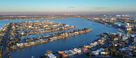 Vista aérea de una zona residencial costera con numerosas casas y barcos, conectada por carreteras y vías fluviales.