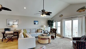 A spacious living room with a sofa, armchairs, a coffee table, and a ceiling fan. - Jolly Dave's by Topsail Realty (Holly Ridge)