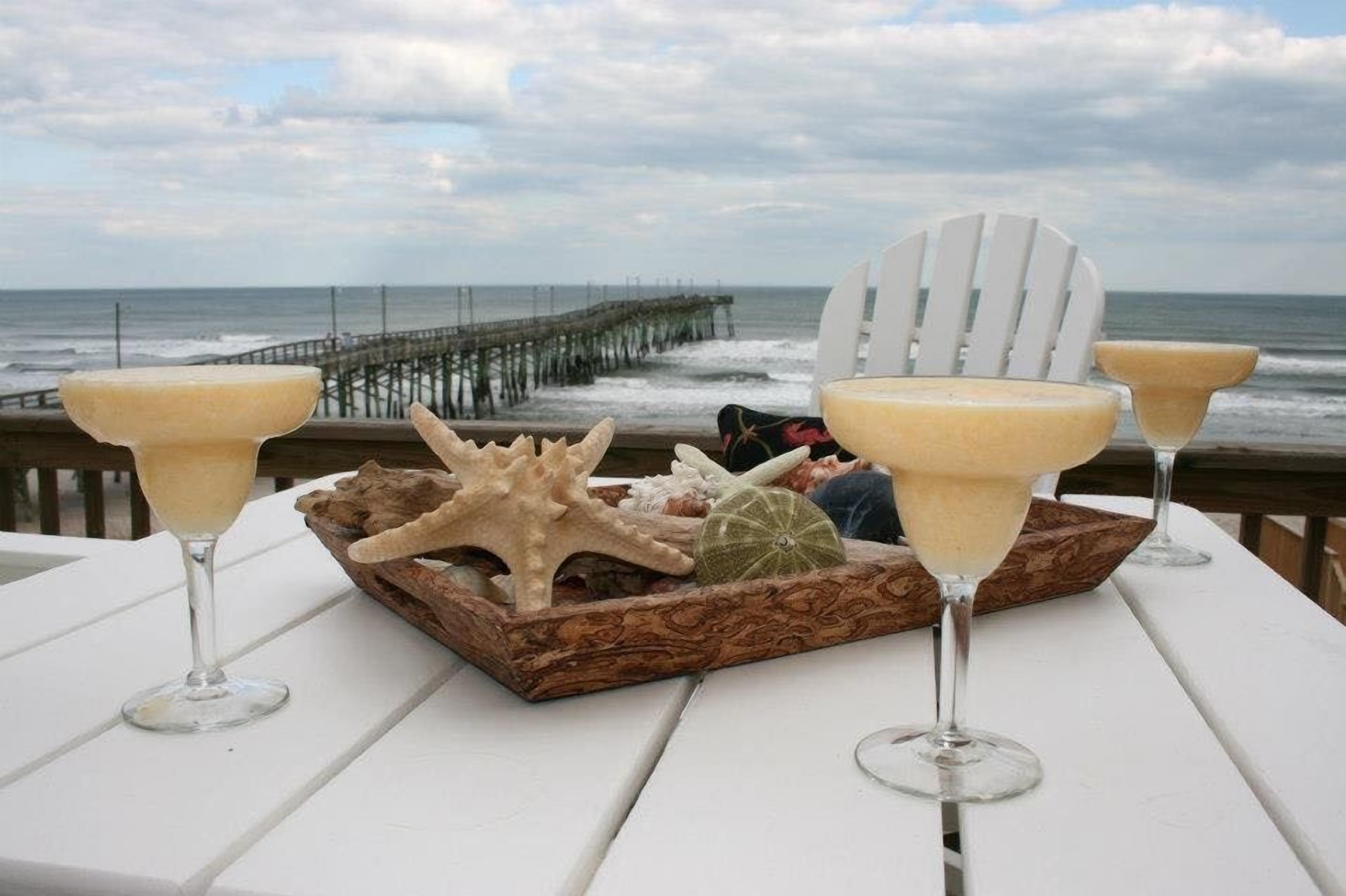 Un tavolo con due bicchieri Martini e un vassoio con decorazioni a tema marino.
