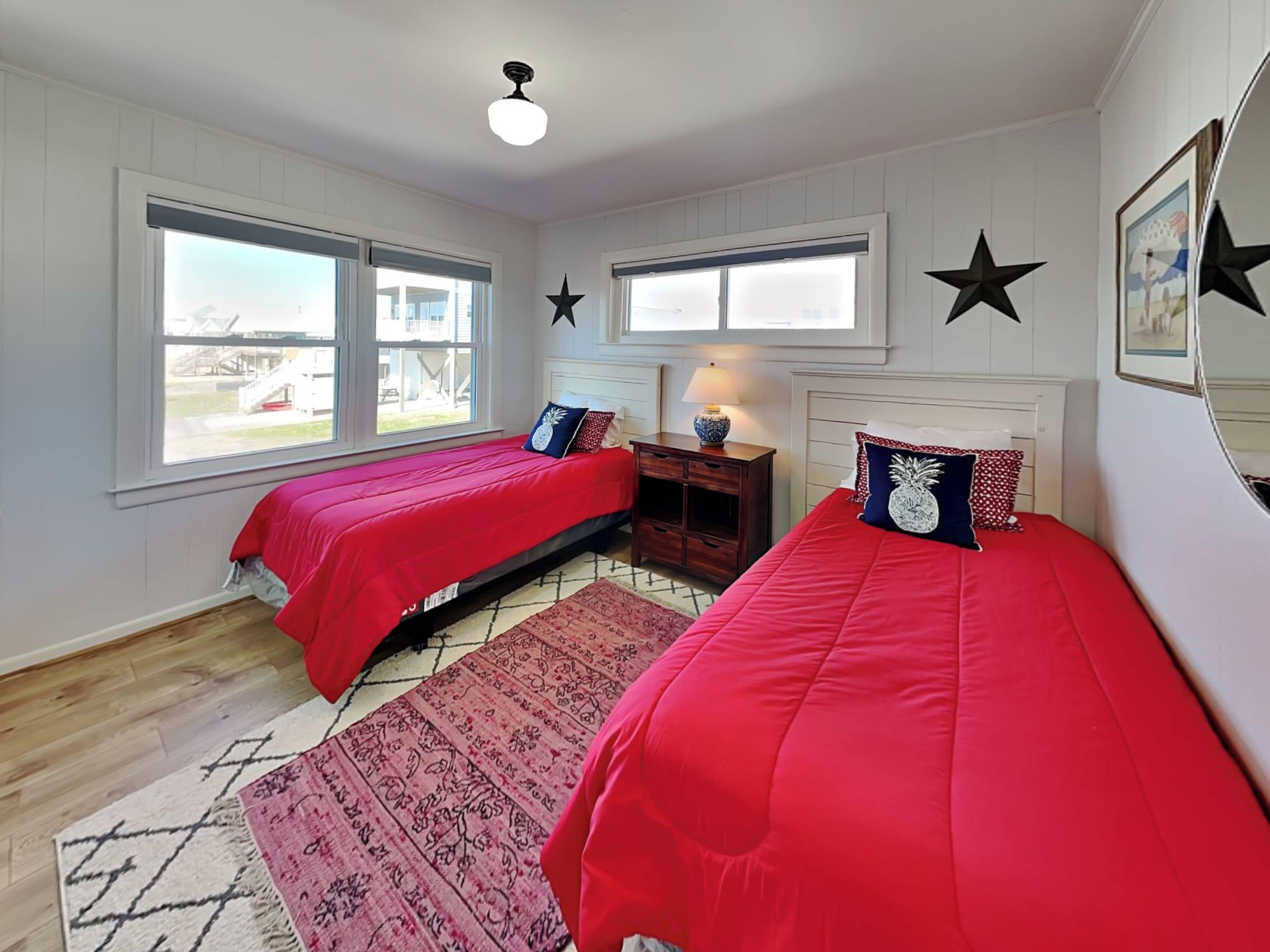 A bedroom with two single beds, a nightstand, a lamp, and a star decoration on the wall.