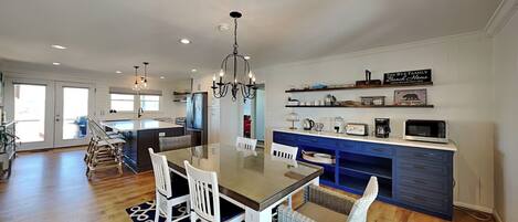 A spacious kitchen with a central island, white cabinetry, and a blue accent wall.