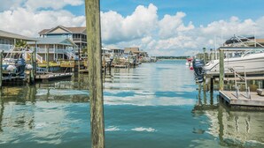Un port de plaisance avec des bateaux amarrés, des quais en bois et un bâtiment doté d’un balcon.