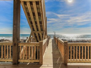 A wooden deck leading to a beach with a clear view of the ocean. - Sunshine Daydreams by Topsail Realty (Holly Ridge)