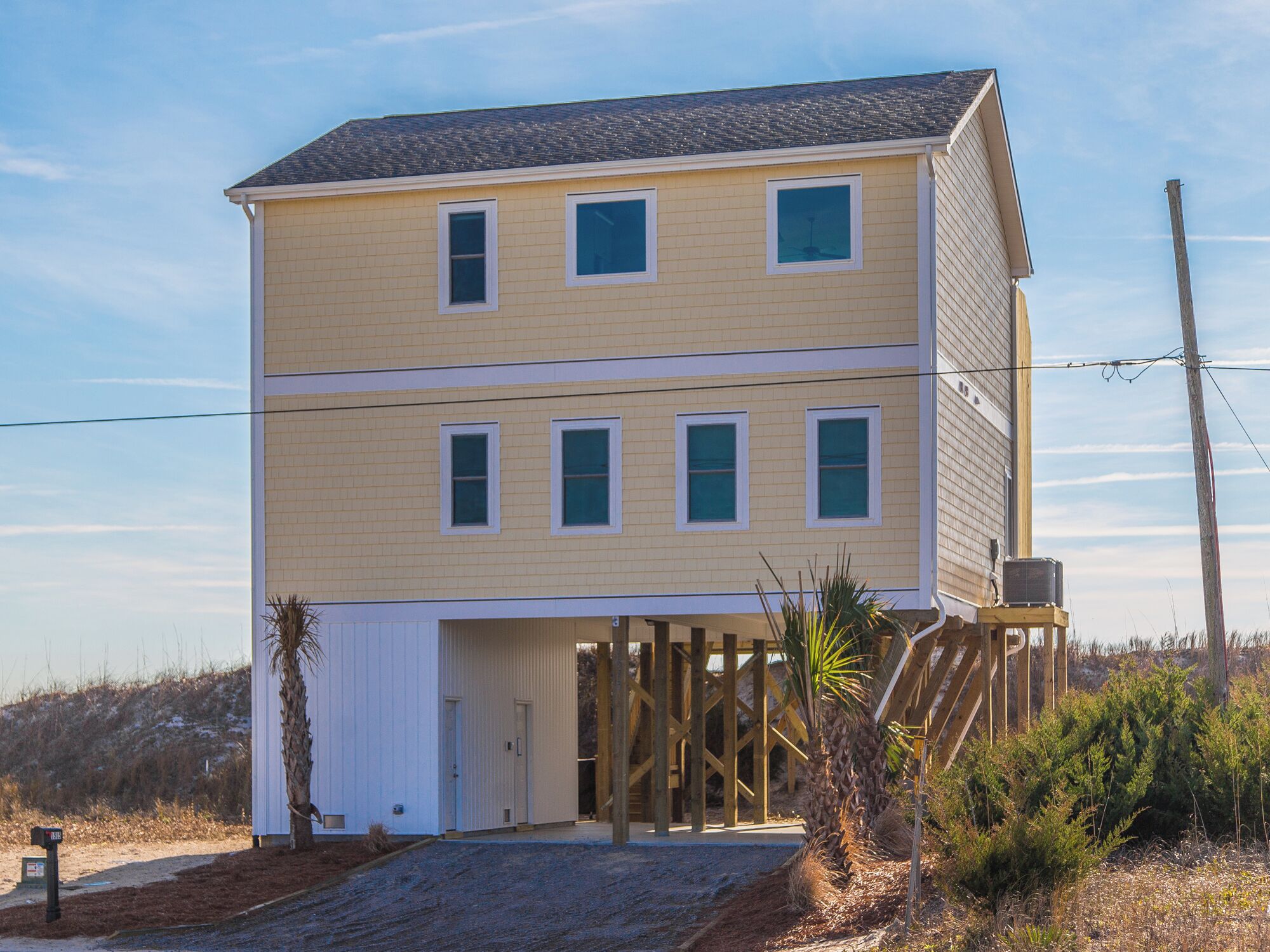 A two-story house with a front porch, a garage, and a wooden deck.