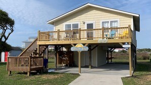 A two-story house with a wooden deck and a sign reading "Sunset Bay." - Sunset Bay by Topsail Realty (Sneads Ferry)