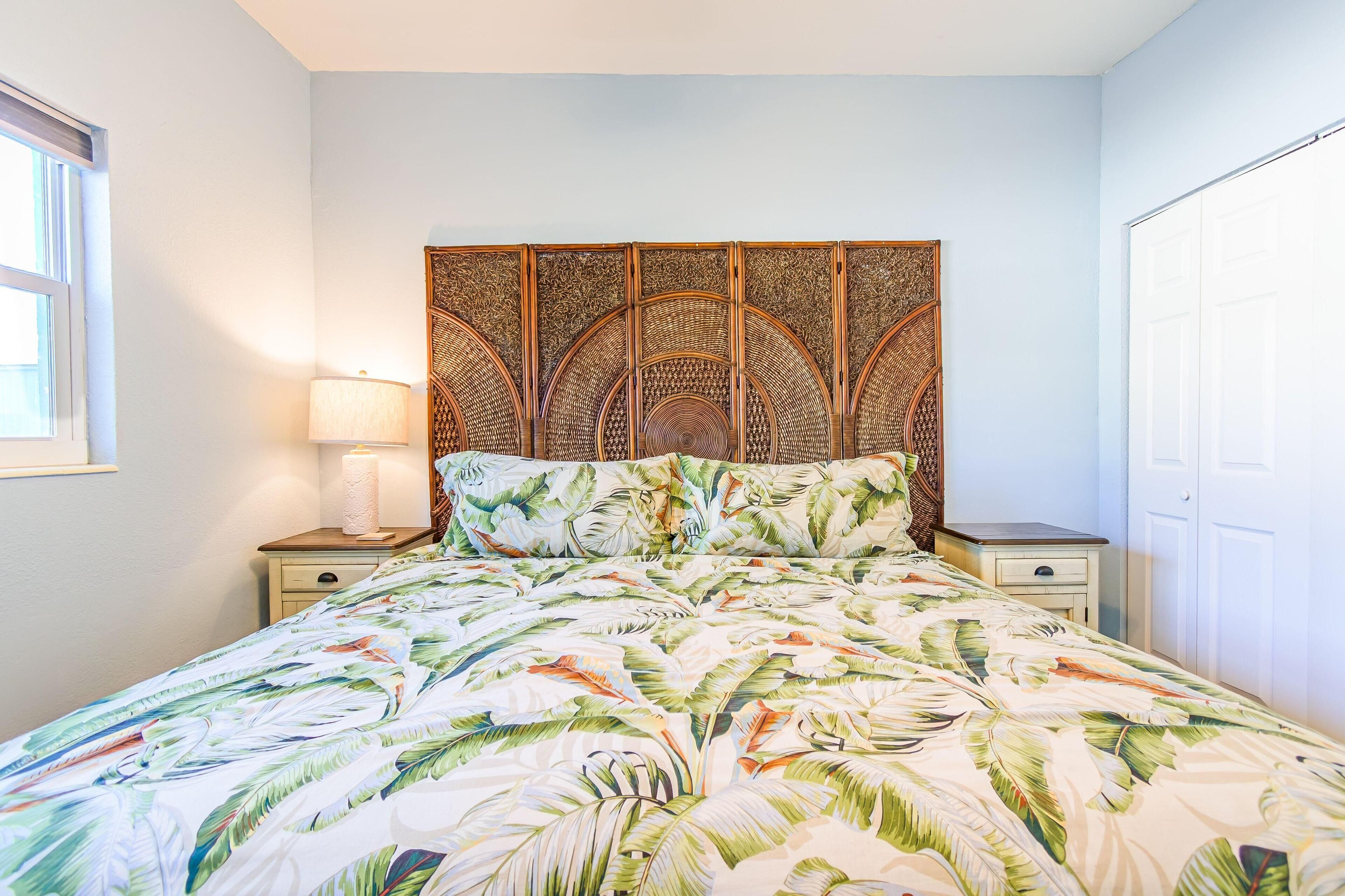 Une chambre à coucher comprenant un lit, une table de chevet, une lampe et une tête de lit décorative.