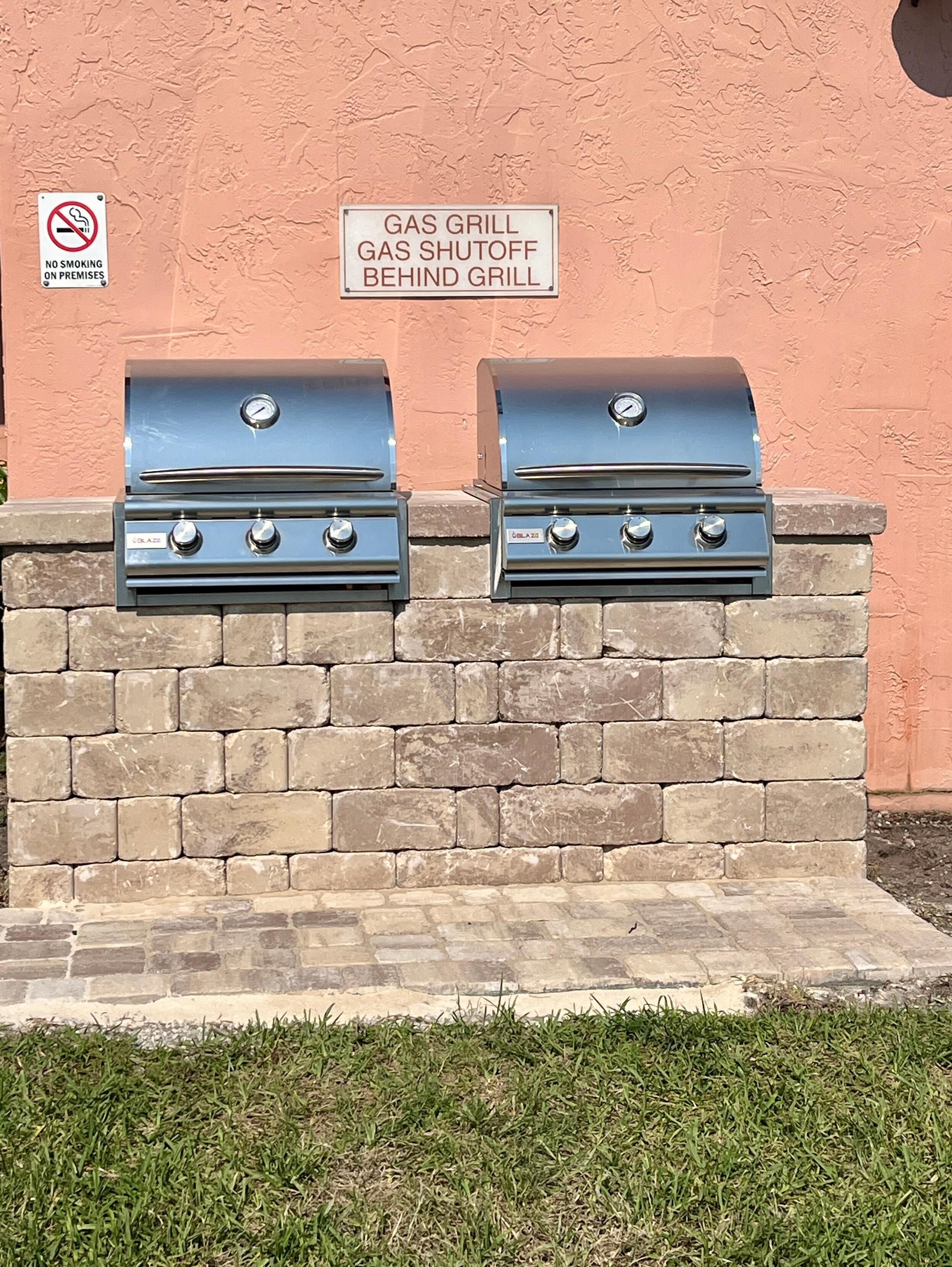 Un barbecue à gaz doté d’un dispositif d’arrêt situé à l’arrière, fixé à un mur en pierre.