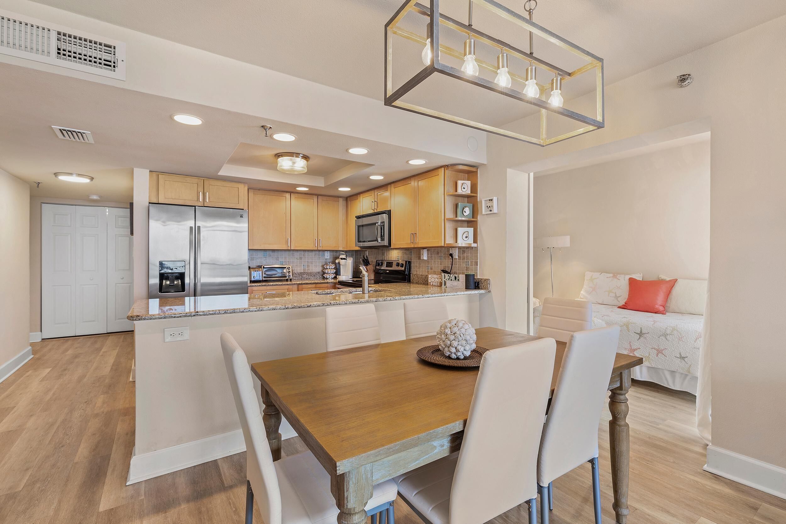 A modern kitchen with wooden cabinets, stainless steel appliances, and a central island with seating.