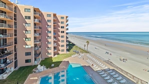 A multi-story hotel with a pool and beach view. - Sunrise 502 (New Smyrna Beach)