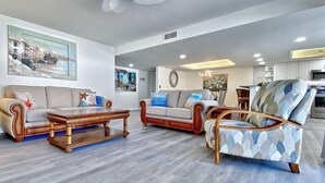 A modern living room with two sofas, a coffee table, and a patterned armchair. - Sea Club #46 - Coastal Gem (Indian Shores)