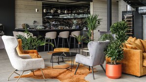 Un intérieur moderne avec un bar, des sièges et des plantes en pot.