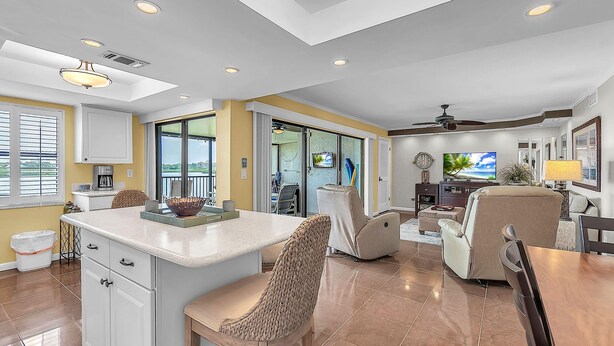 A spacious living area with a kitchen, dining table, and comfortable seating. - Sea Club #29 - Our Sunrise Nest (Indian Shores)