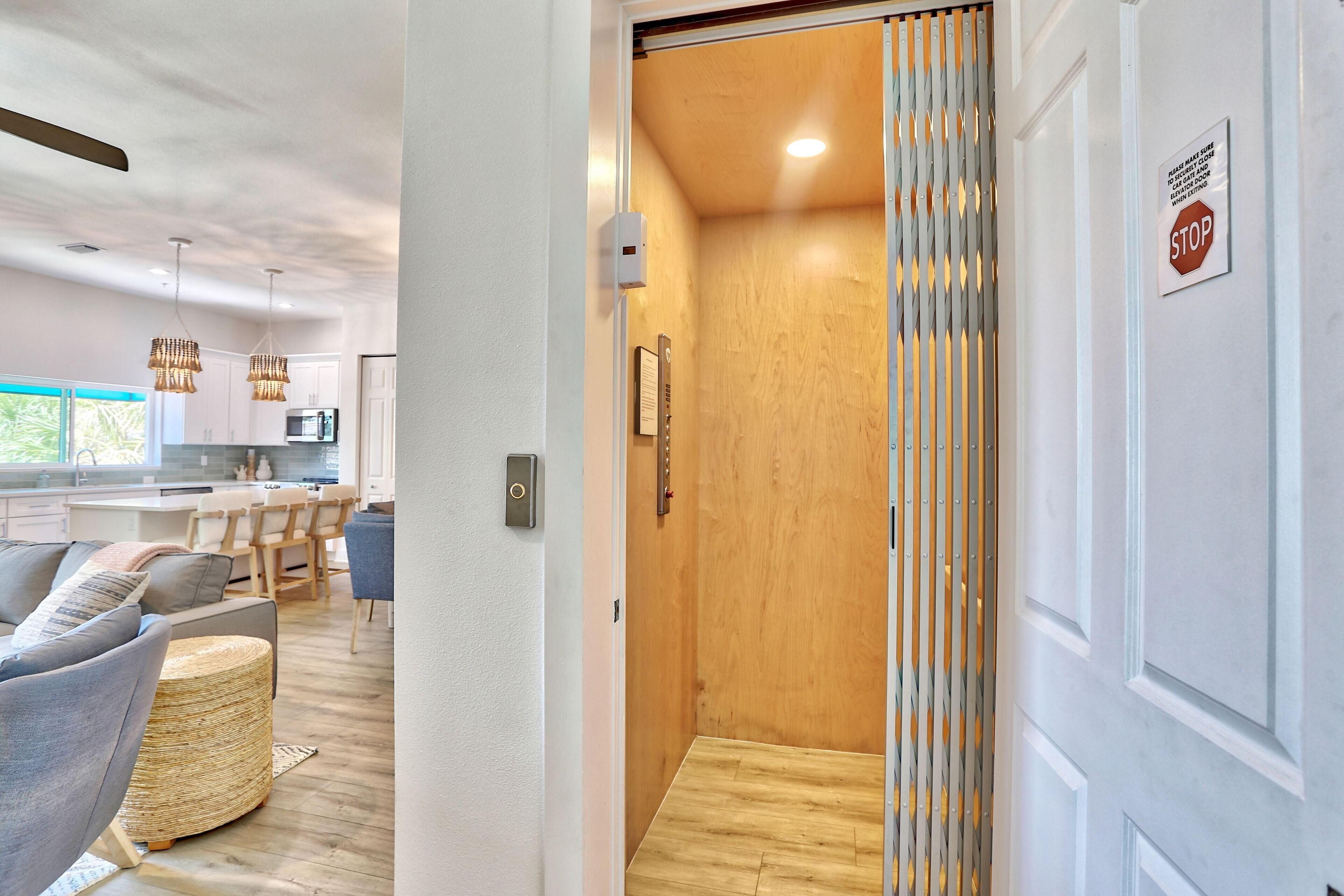 A modern interior with a wooden door, a stop sign, and a view into a kitchen area with a dining set.