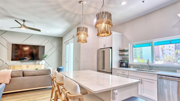 Cocina moderna con una isla central, electrodomésticos de acero inoxidable y un amplio ventanal con vistas.