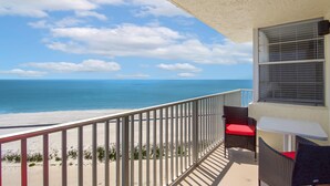 Un balcon avec vue sur la plage et l’océan.