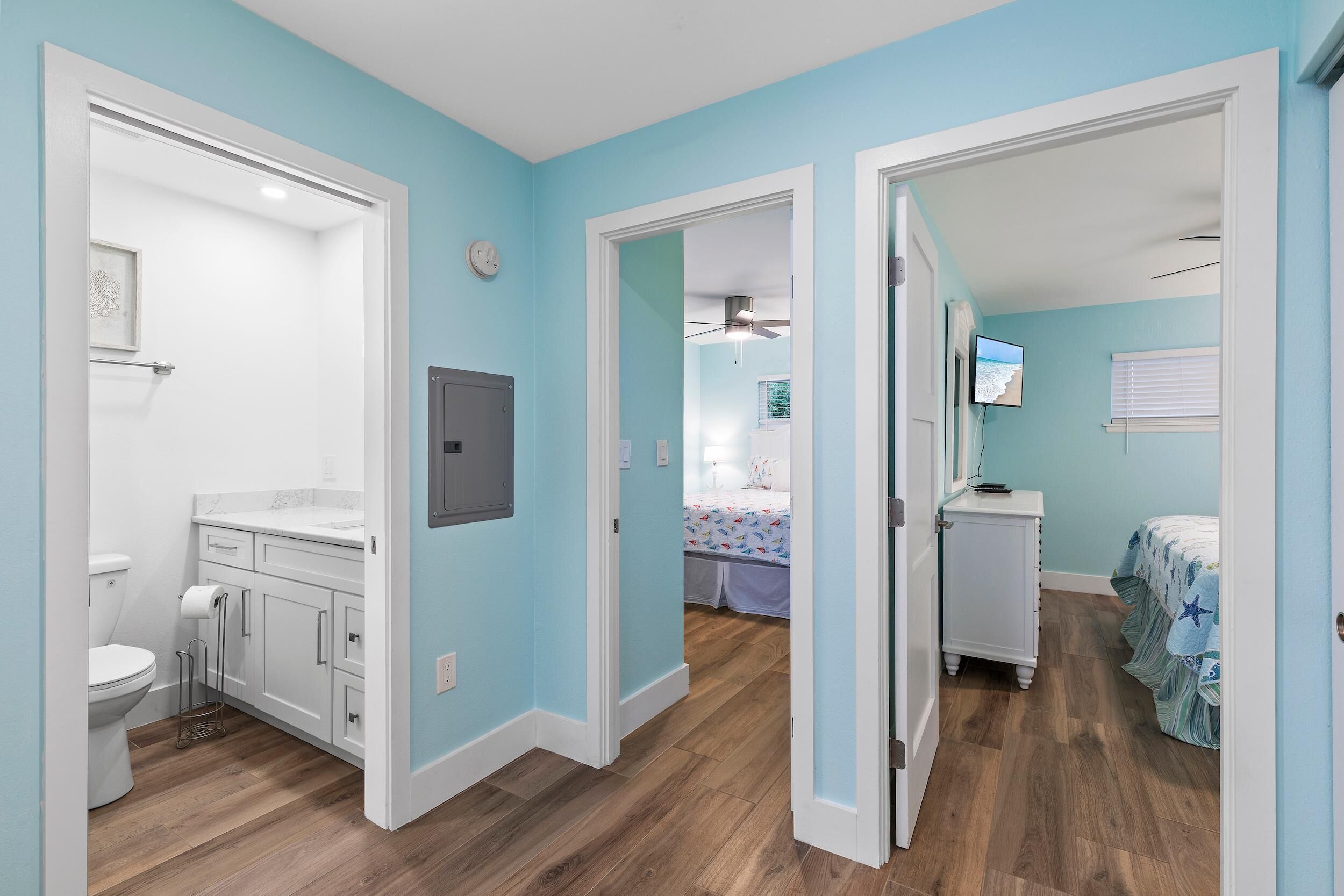 A room with a bathroom, a bed, and a desk.