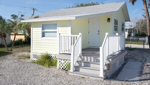 A small, single-story building with a white exterior and a porch. - Island Paradise Cottage (Fort Myers Beach)