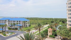 Ein Hotel mit einem blau gedeckten Gebäude, einem Schwimmbad und Blick auf einen Golfplatz.