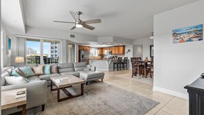 A modern living room with a sofa, coffee table, and a dining area with chairs.