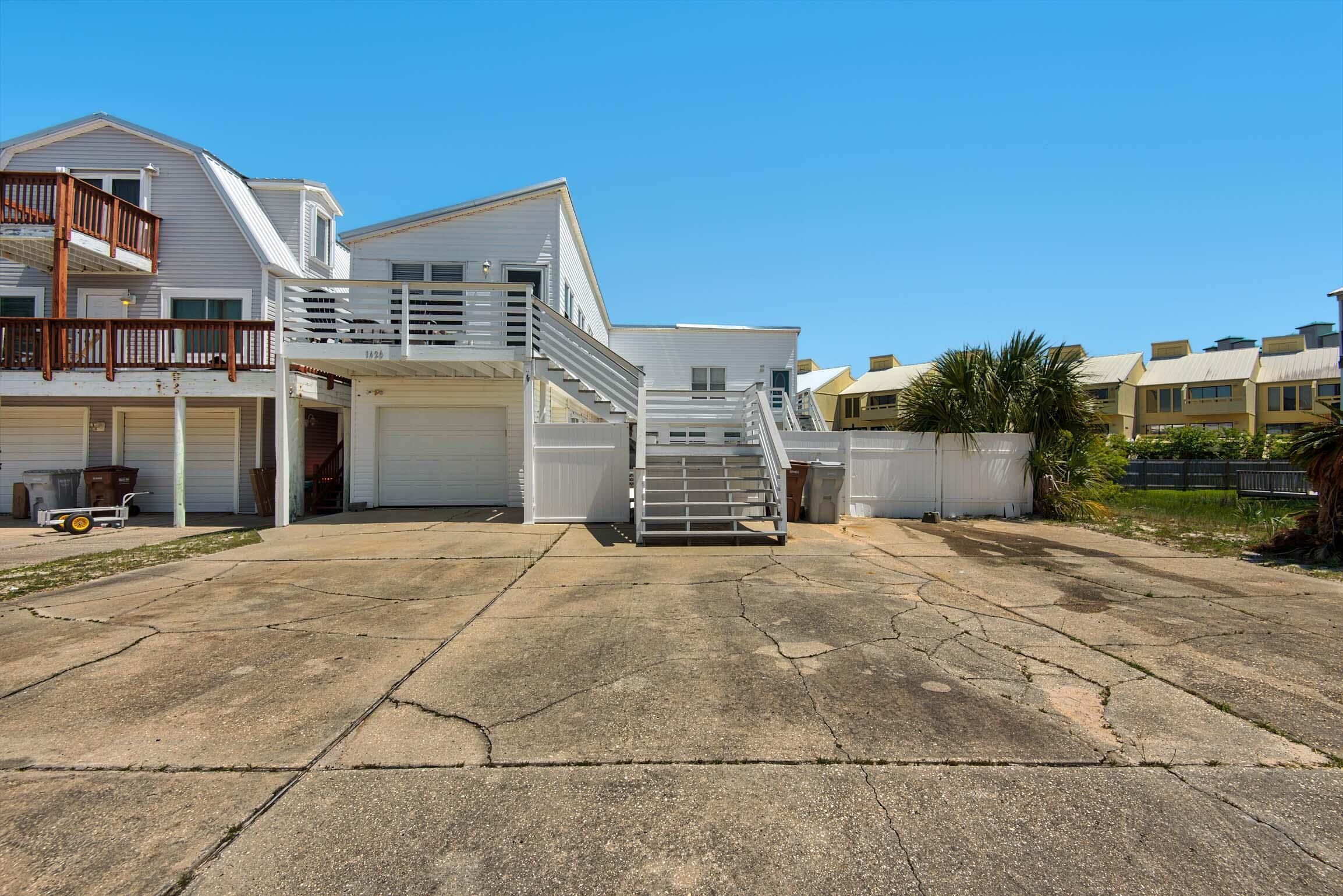 A two-story building with a garage, a staircase, and a balcony.