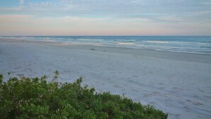 A beach with a clear sky and calm sea. - Point East 314 (New Smyrna Beach)