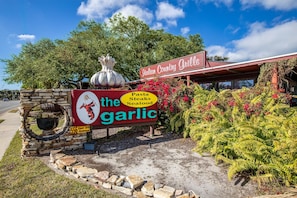 Letrero de restaurante que dice 'The Garlic', con un logotipo de un bulbo de ajo y un chef.