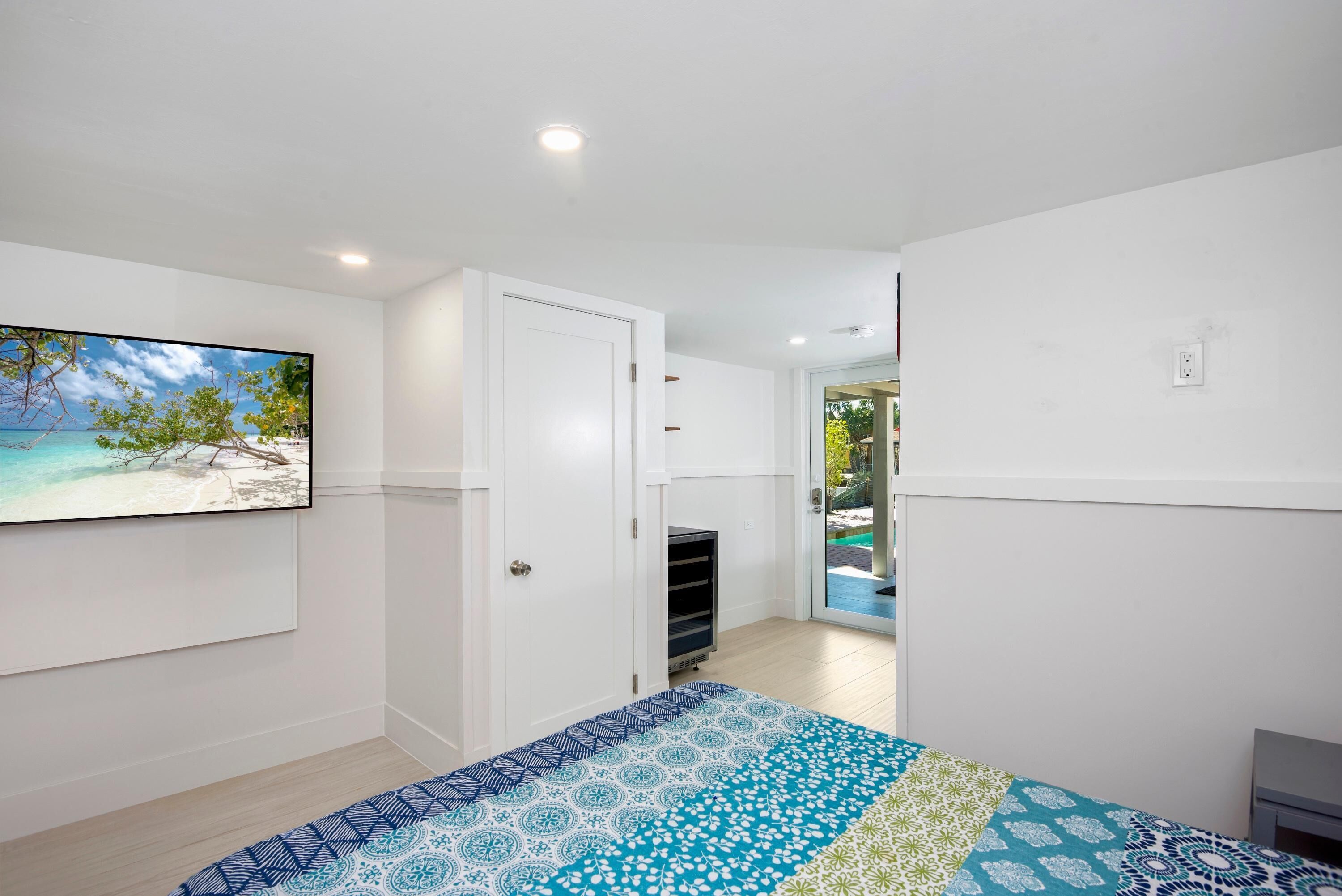 A bedroom with a bed, a wardrobe, and a door leading to a balcony.