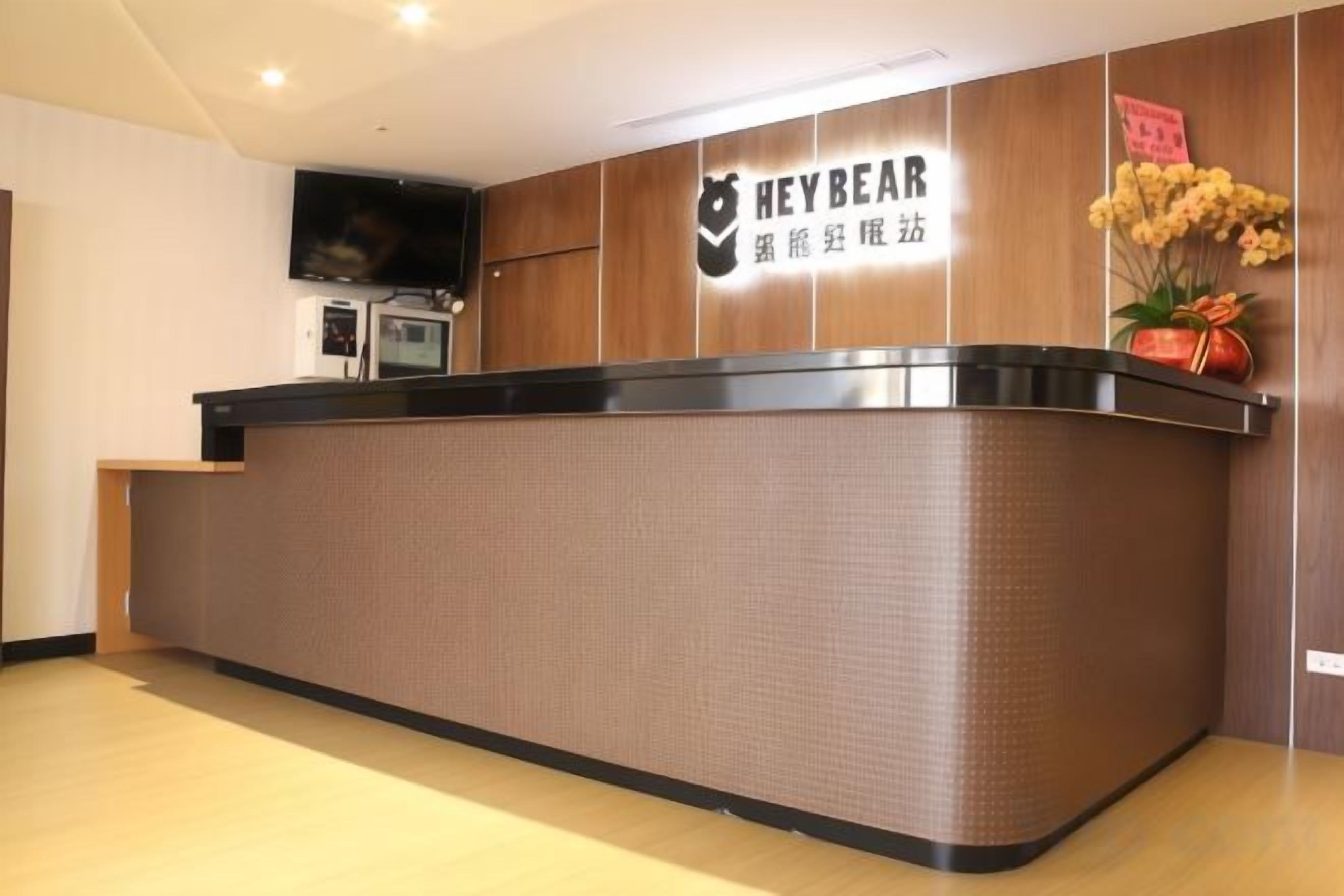A reception desk with a sign that reads 'HEYBEAR' and a television mounted on the wall.
