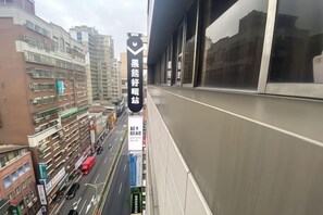 A view of a city street from a high-rise building with a large window. - Hey Bear Capsule Hotel (Xinbei Taipei Bridge Metro Station) (New Taipei City)