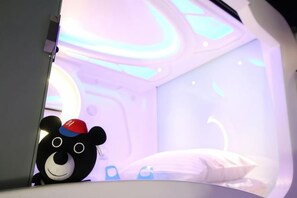 A room with a bed, a bear plush toy, and a window with a view. - Hey Bear Capsule Hotel (Xinbei Taipei Bridge Metro Station) (New Taipei City)