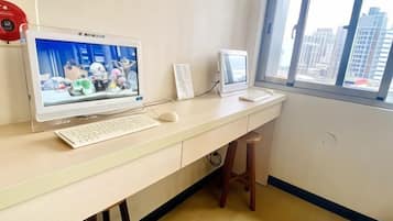 A computer desk with a monitor, keyboard, and mouse.
