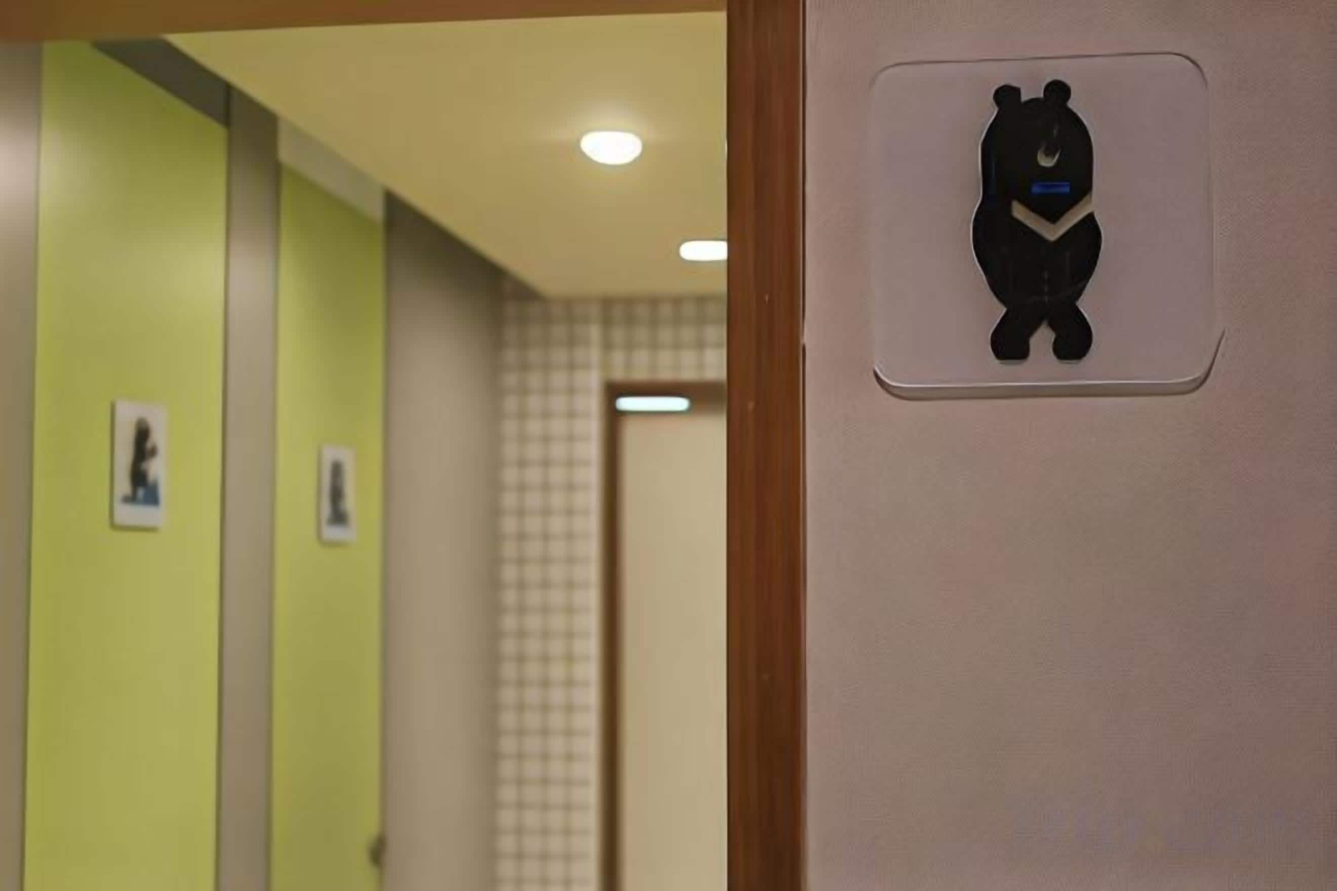 A hallway with a bear symbol on the wall, indicating a children's area.