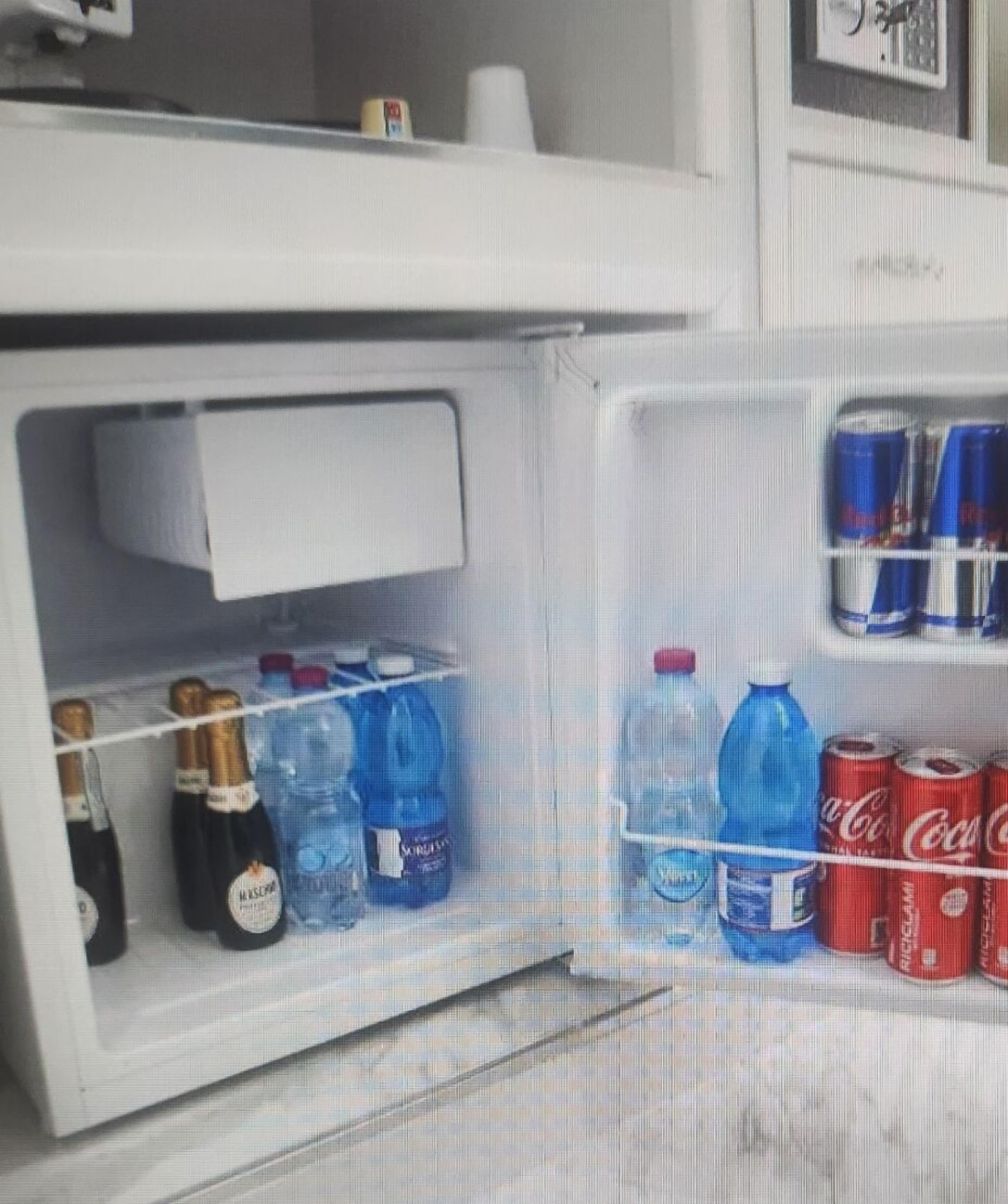 A refrigerator stocked with various beverages including champagne, water, and soda.