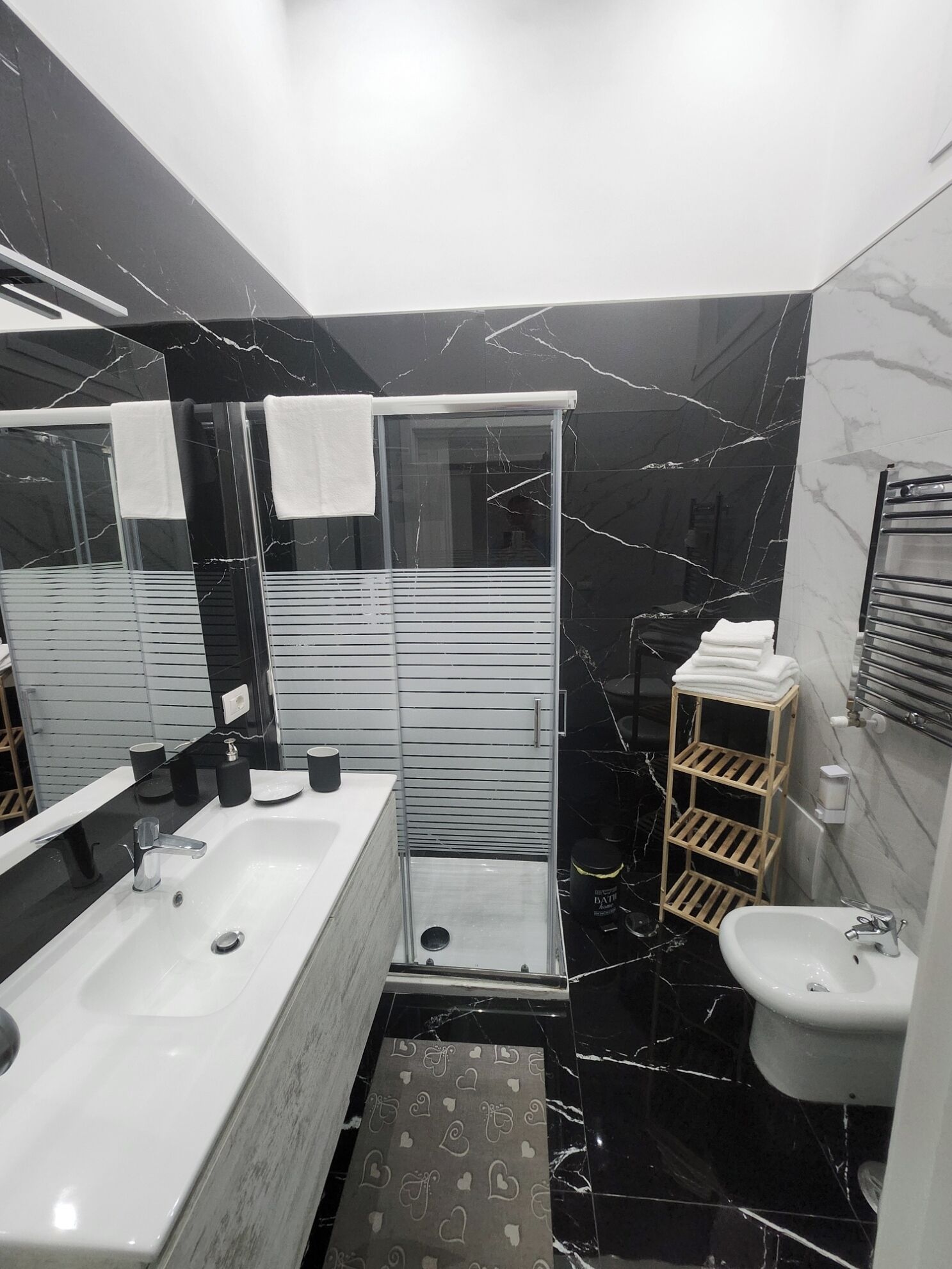 Een moderne badkamer met een groot bad, een apart wastafelmeubel en een douchehoek.